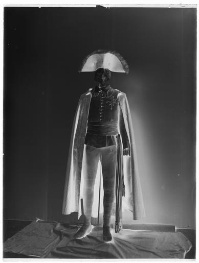 Livrustkammaren - 68578-negative.tif Jackan har nationella dräktens snitt med kroppsnära skärning och vida skört axelkarmar och snäva ärmar Kvaliteten är småmönstrad silkestrikå i en ljusbrun-och blågrönmönstrad tråd som vid ...