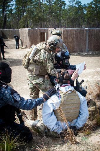 TIGRES Eglin AFB 383942.jpg en A Green Beret from the 7th Special Forces Group Airborne helps Honduran Tigres understand information on a document discovered while searching a detainee role-played by a Soldier from the unit Feb 27 2015 ...