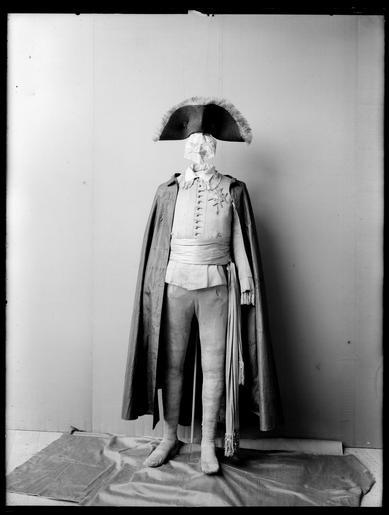 Jacka maskeraddräkt - Livrustkammaren - 68578.tif Jackan har nationella dräktens snitt med kroppsnära skärning och vida skört axelkarmar och snäva ärmar Kvaliteten är småmönstrad silkestrikå i en ljusbrun-och blågrönmönstrad ...